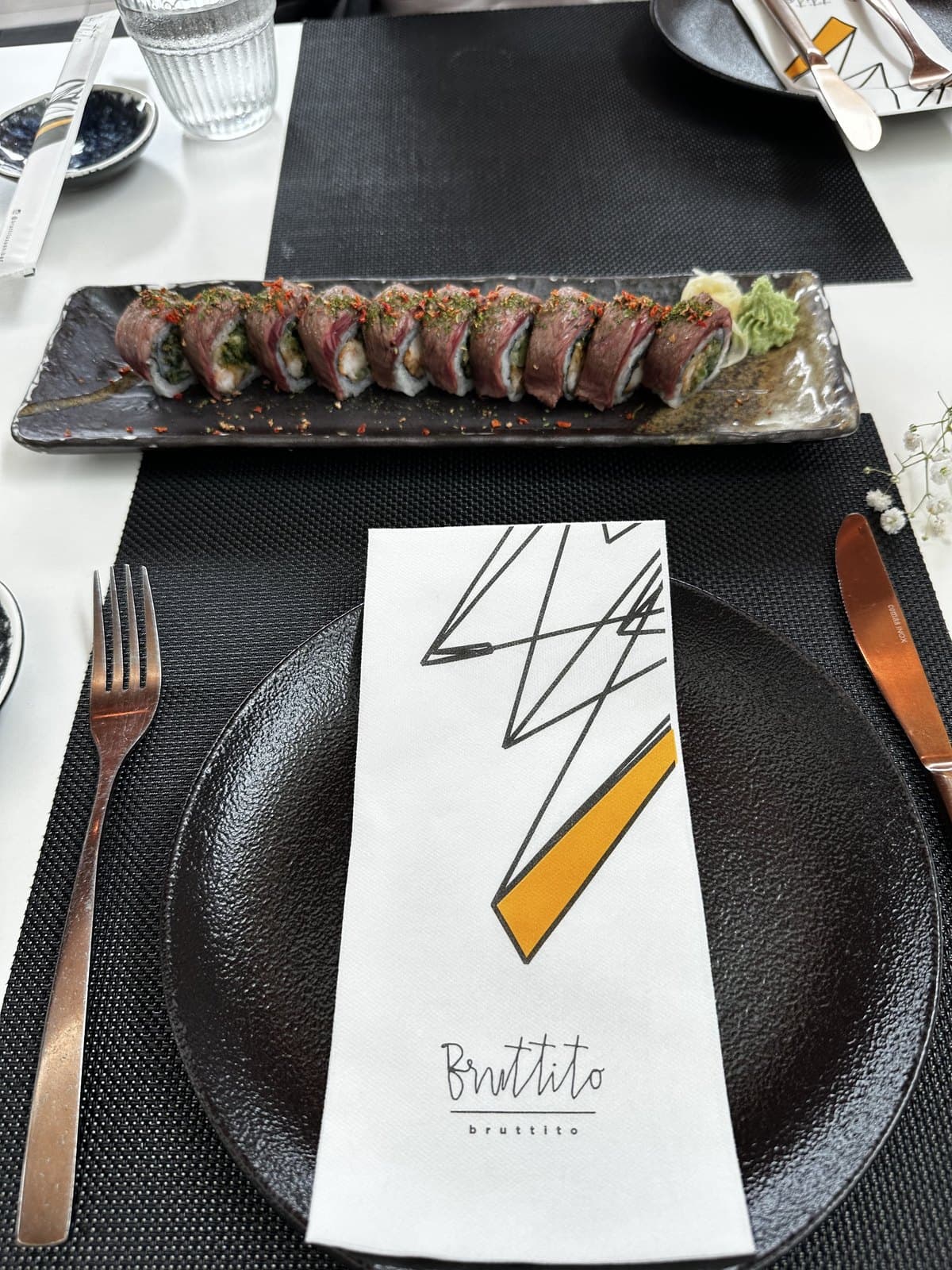 The Angus 15 roll at Bruttito: seared beef wrapped around rice, sliced along a dark slate