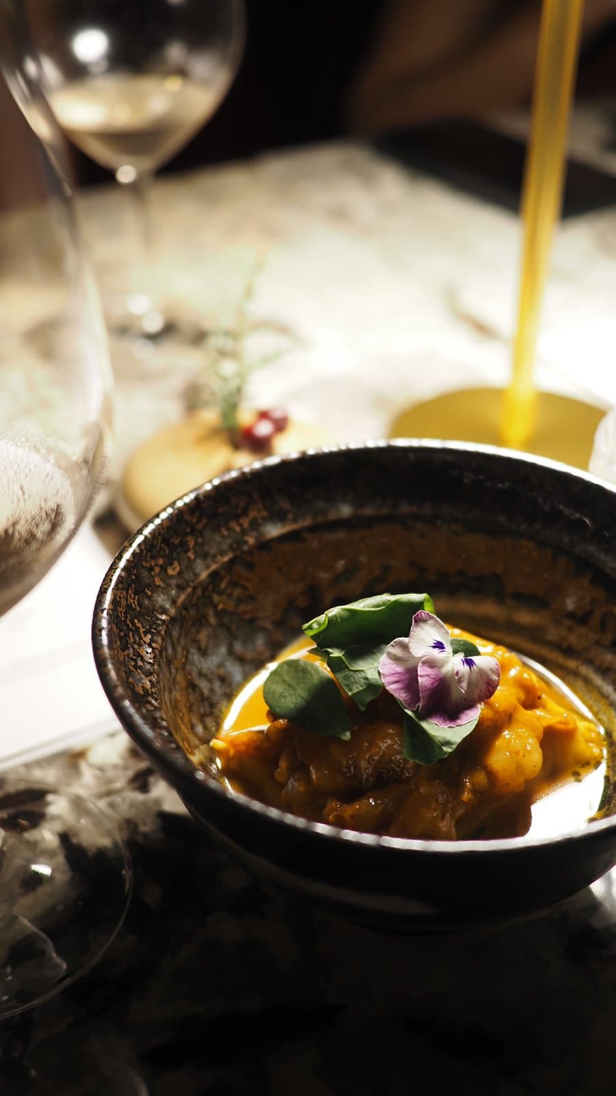 Short rib with macha sauce and pumpkin foam at Caleta, finished with an edible flower