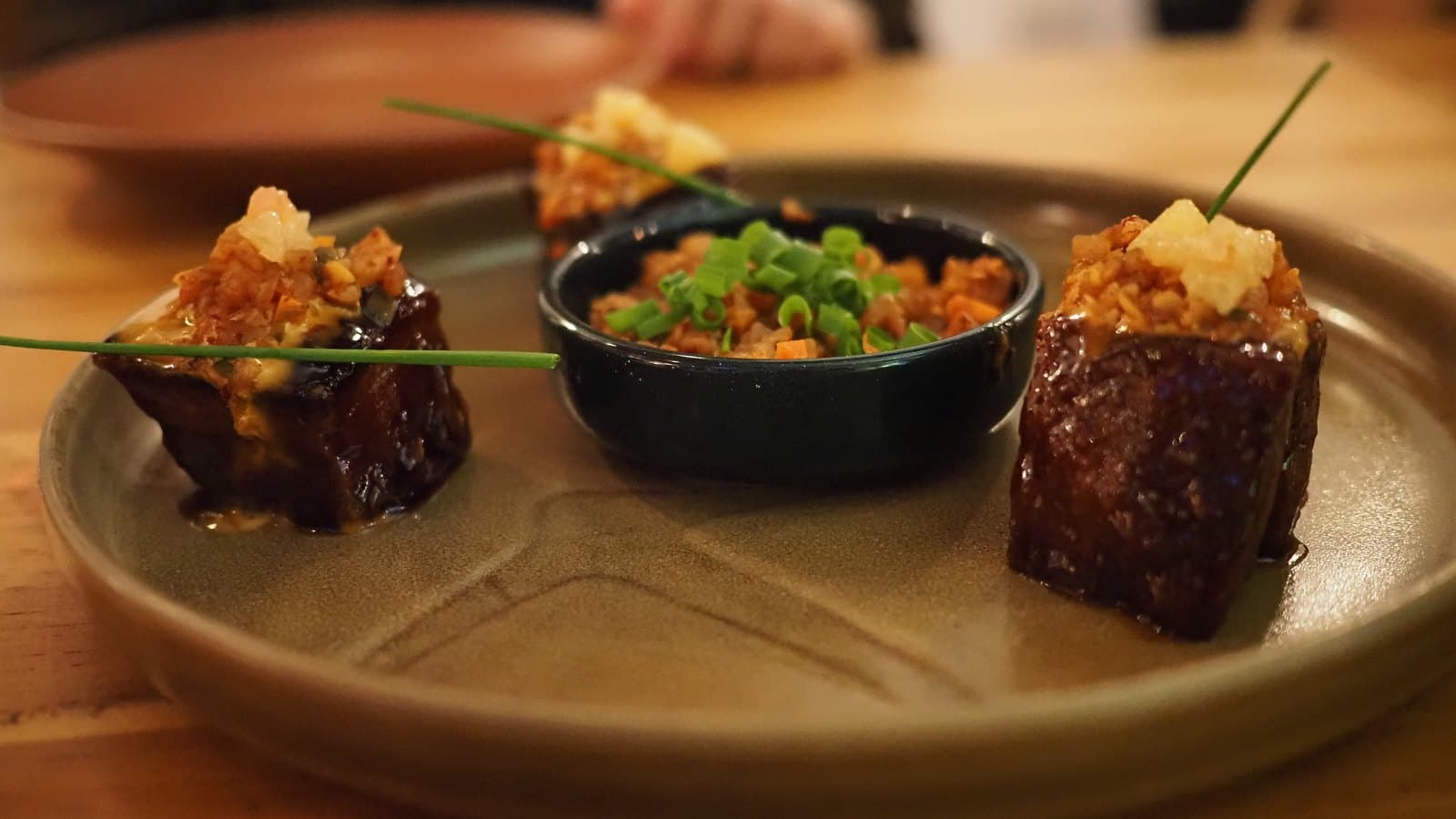 Pork belly pops at Kaandela: glazed cubes of pork under a crisp topping, with a small bowl alongside
