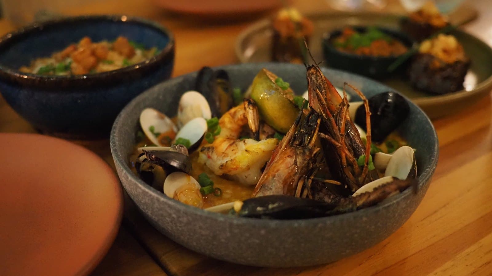 The seafood casserole at Kaandela: prawns, mussels and clams with potato in a broth, in a speckled bowl