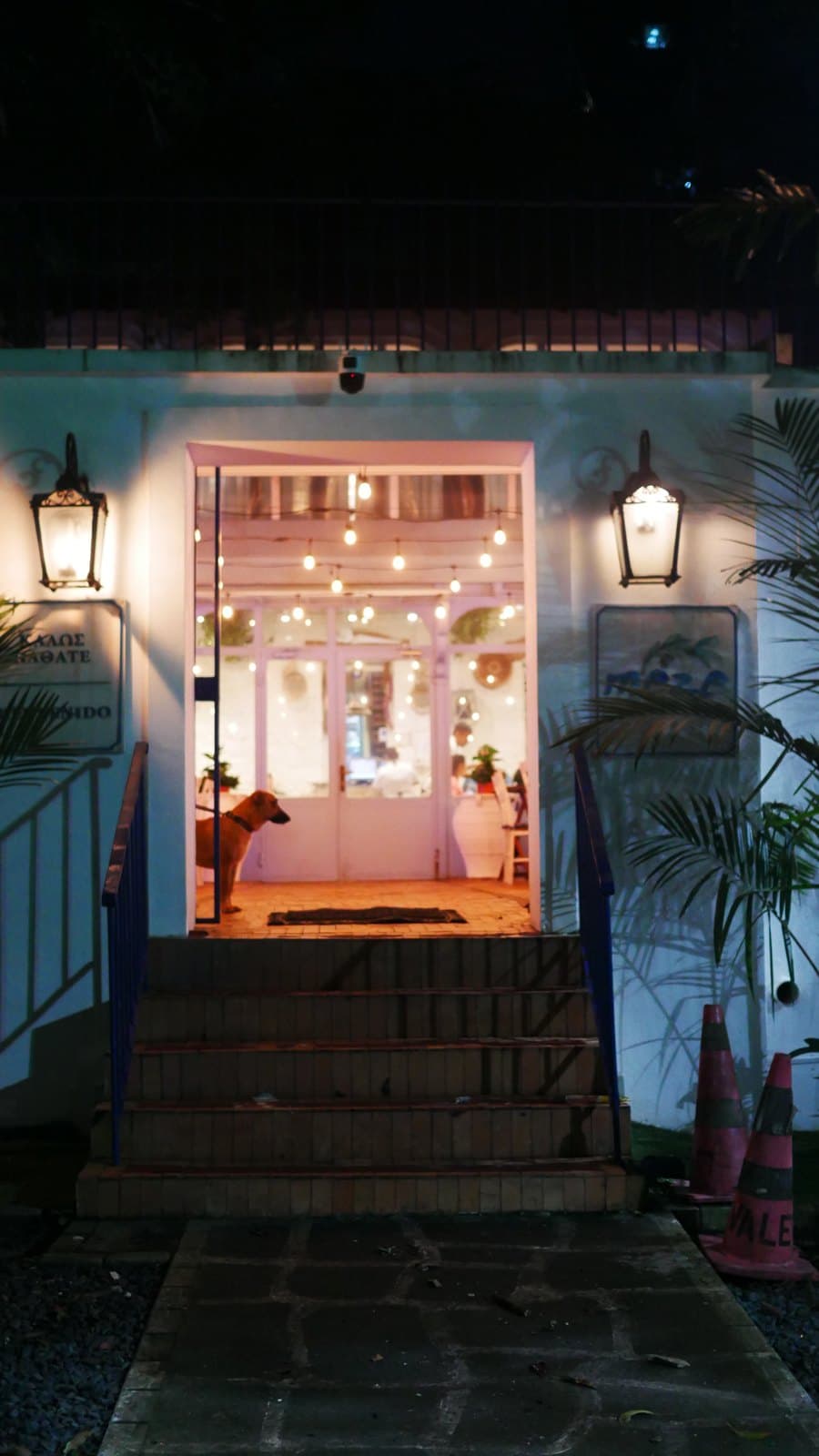 The lit entrance to Meze at night, a lantern either side of an open doorway