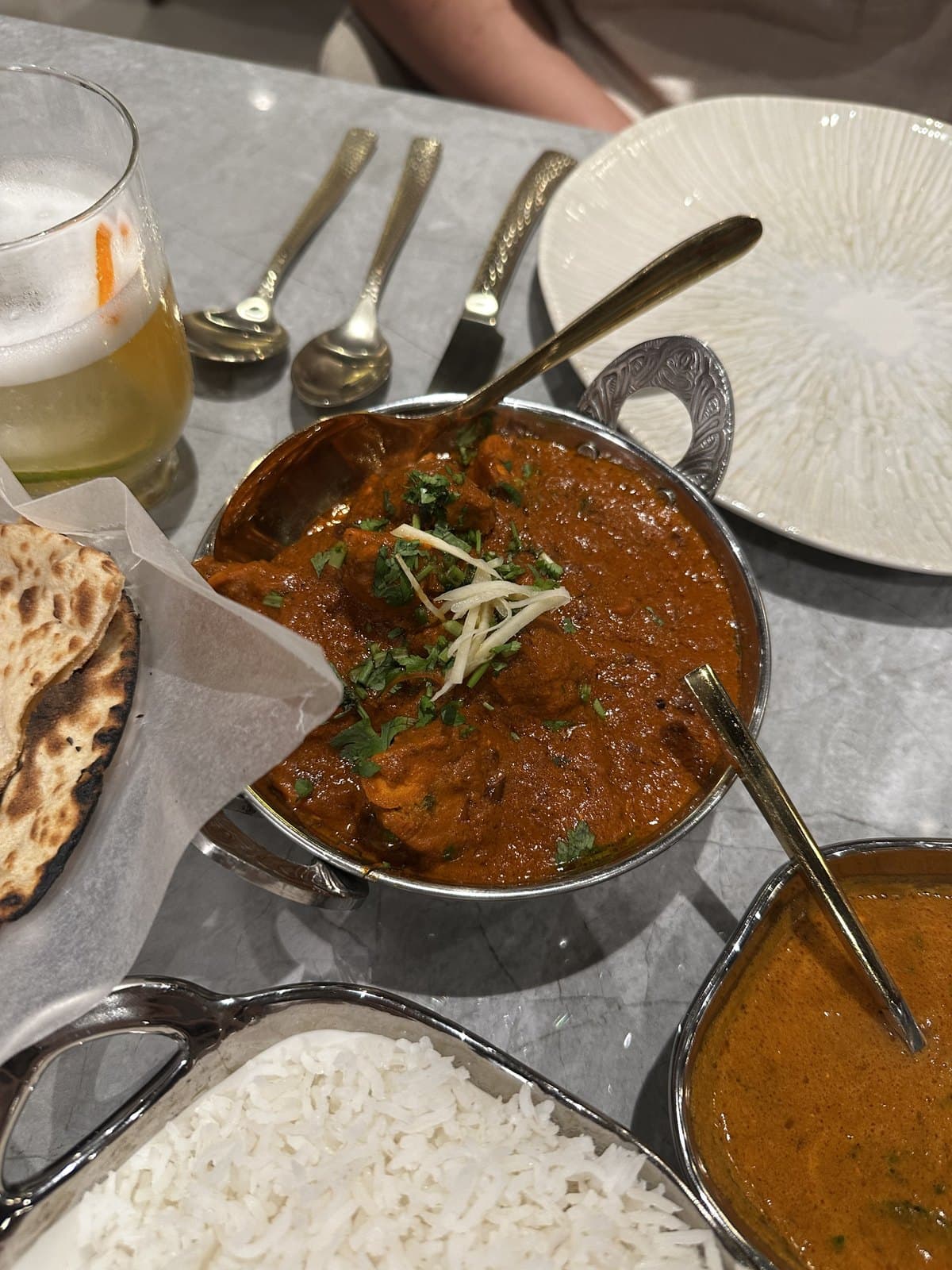 Chicken tikka masala at Mystic India Panama, served in a steel karahi with naan and rice