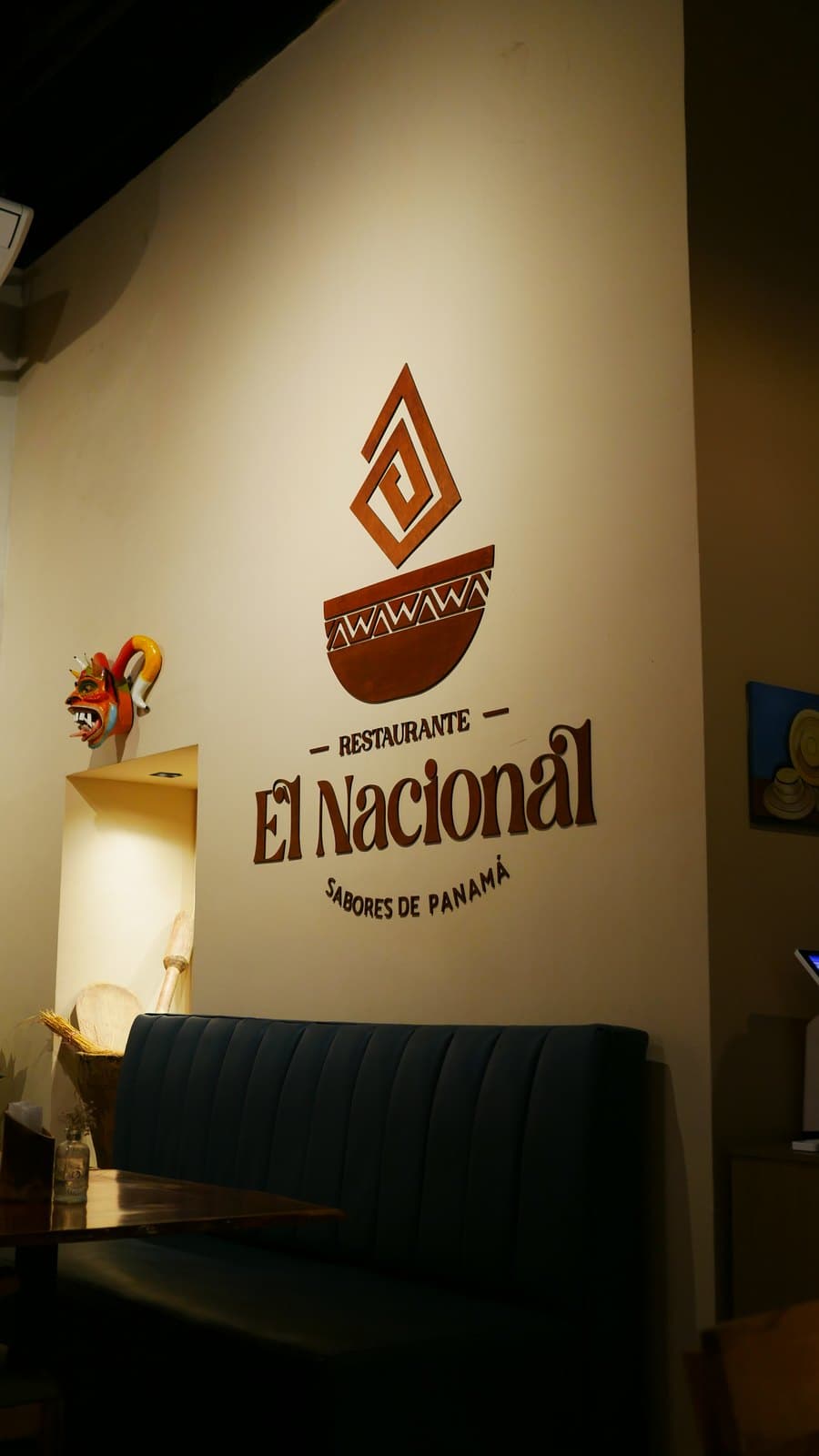 A banquette beneath the El Nacional mark on the dining room wall, Casco Viejo