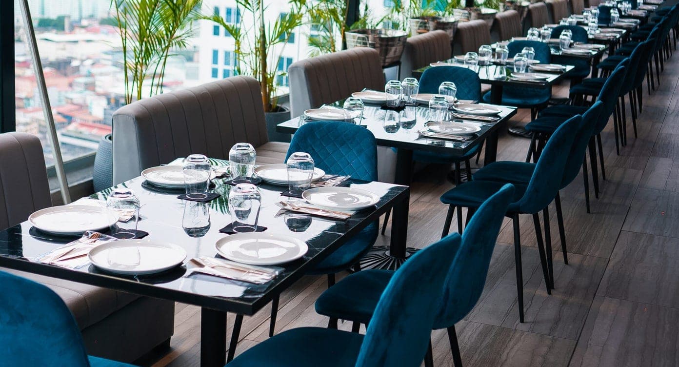 Open-air rooftop terrace with set tables overlooking the Panama City skyline at Cielo Rooftop, Calidonia