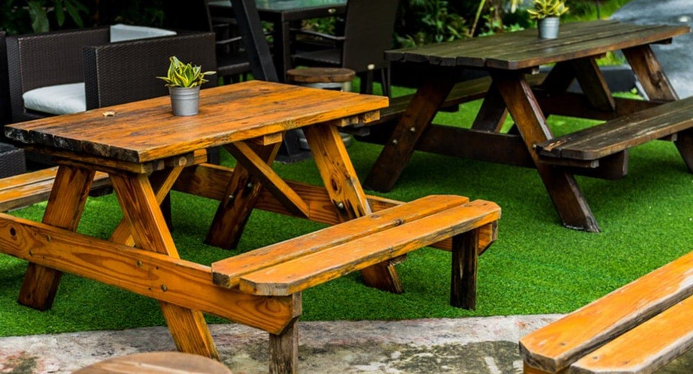 Cervecería al aire libre con mesas de picnic de madera y vegetación tropical en El Cangrejo, Ciudad de Panamá