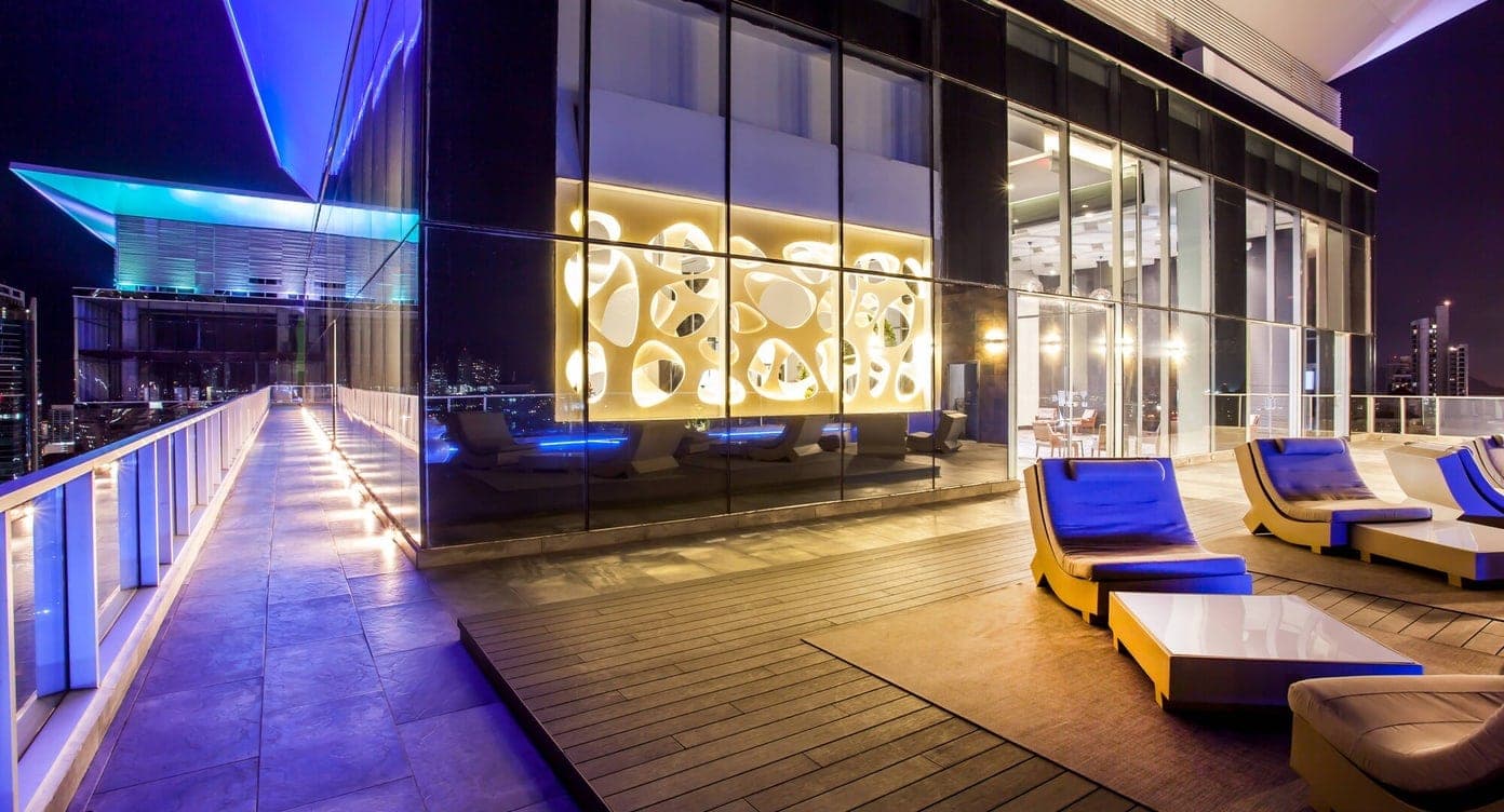 Rooftop terrace at dusk with wood decking, loungers, and the Panama City skyline at Sortis Hotel, Marbella, Panama City