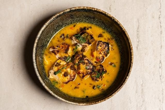 Grilled fish in golden broth at ADAMA, Bella Vista, Panama City