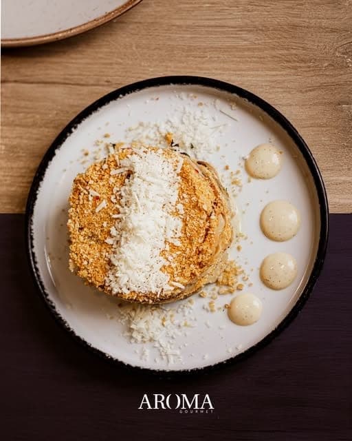 Plato empanizado con queso rallado y salsa cremosa en Aroma Gourmet, Paitilla, Ciudad de Panama
