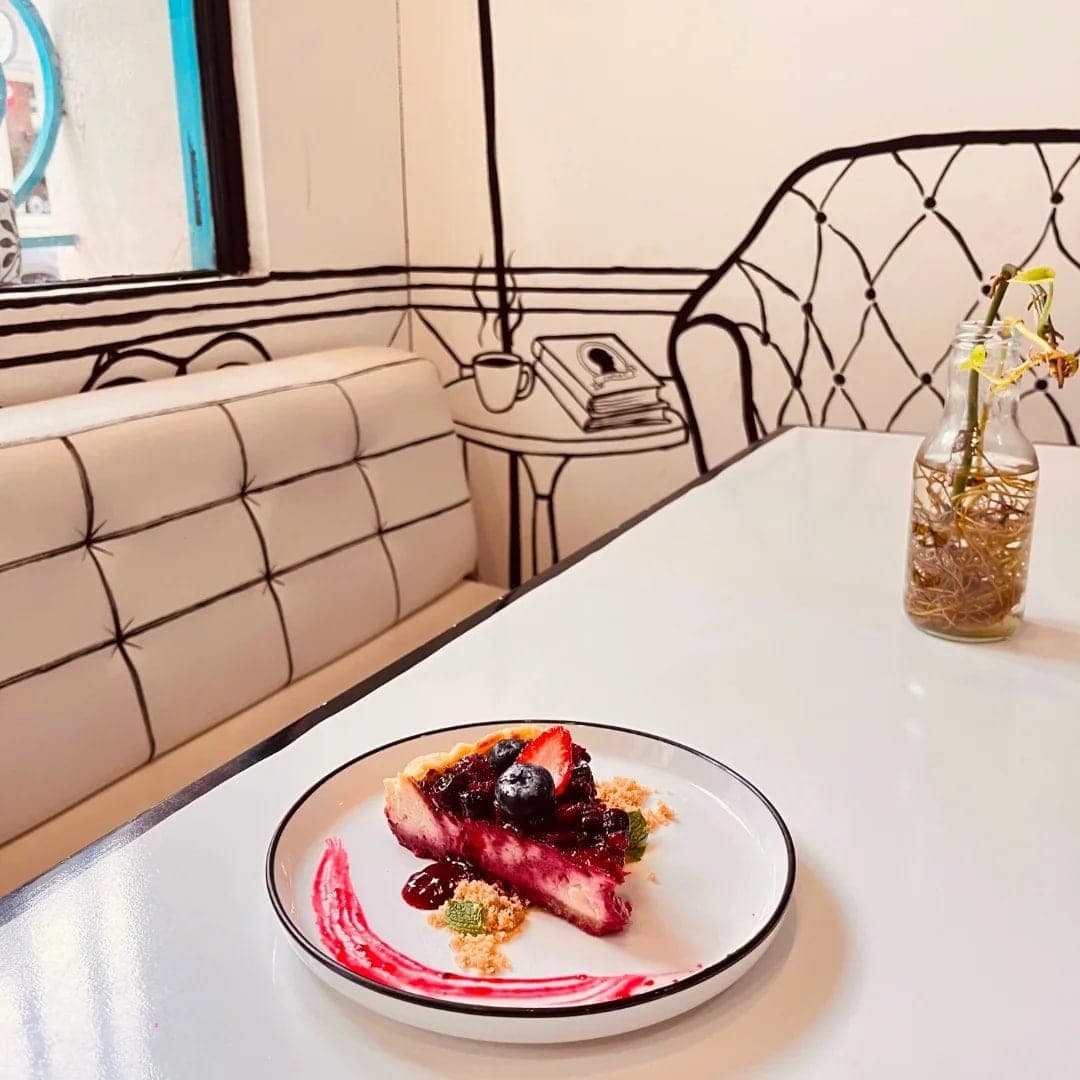 Signature 2D line-art interior with a slice of cheesecake at Baloo Café, Casco Viejo, Panama City