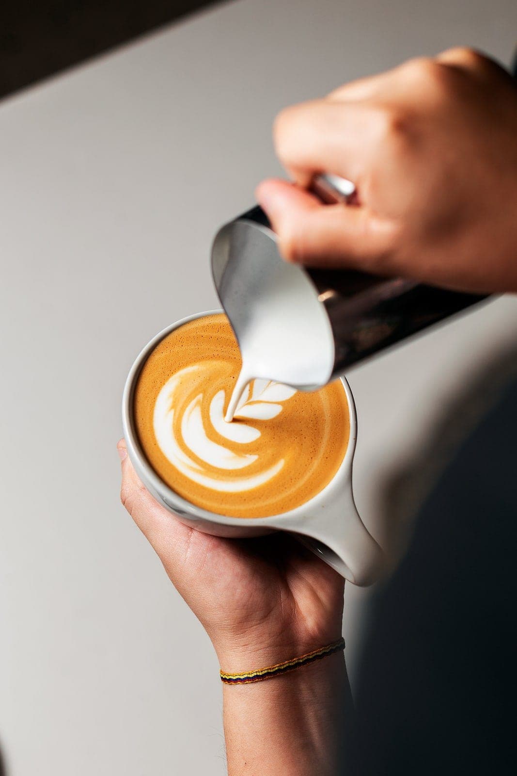 Barista pouring latte art into a Café Unido cup, Casco Viejo, Panama City