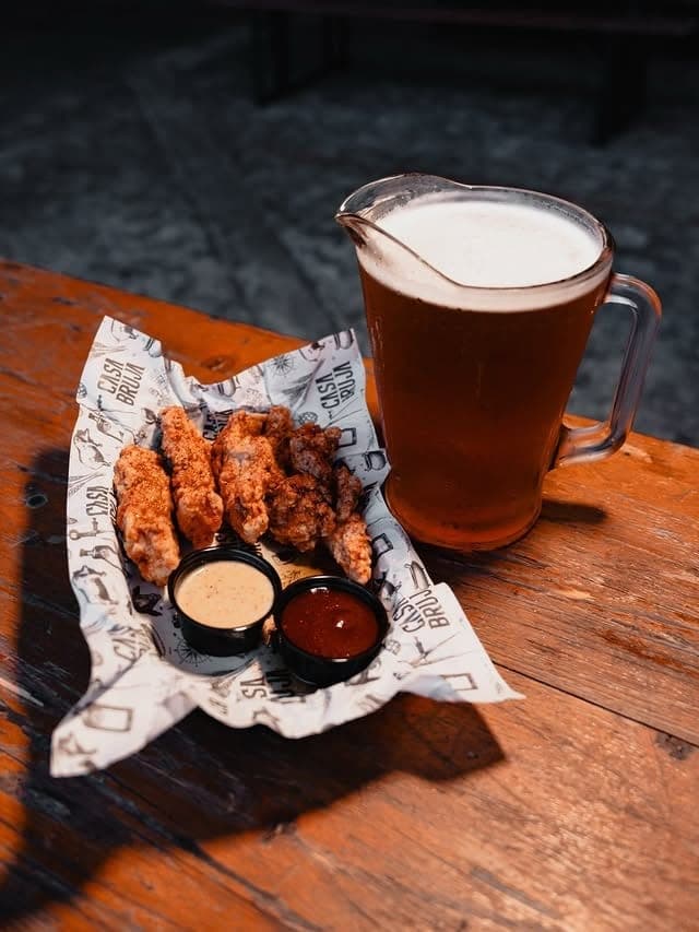 Pitcher of draft beer with honey fried chicken strips at Casa Bruja Brewing Co., Costa del Este, Panama City