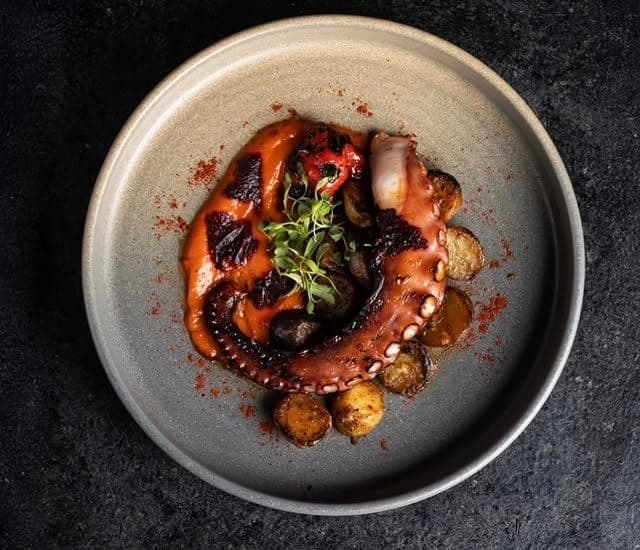Pulpo a la parrilla con papas en plato de piedra en Catch Seafood & Grill, Casco Viejo, Ciudad de Panamá