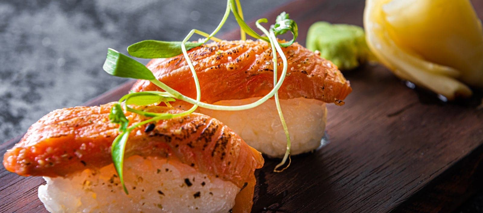 Seared salmon nigiri on a dark board at Enkai, Casco Viejo, Panama City