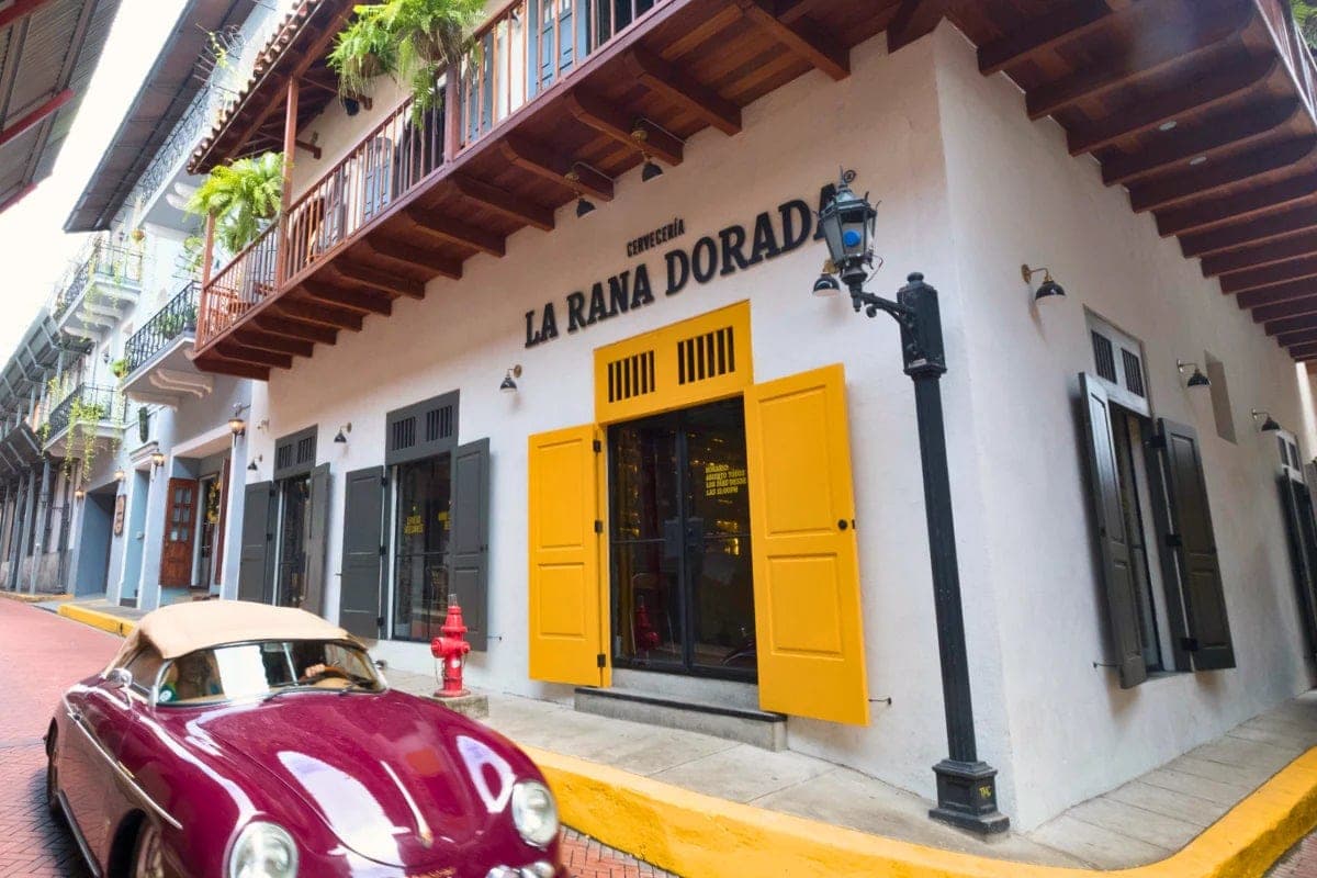 Fachada colonial de esquina de La Rana Dorada Casco Antiguo con postigos amarillos en una calle empedrada, Ciudad de Panamá