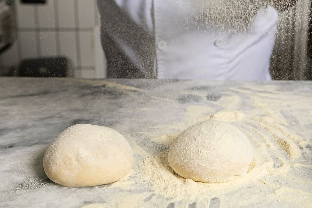 Dos bolas de masa de pizza romana enharinada sobre mármol en Masa, Santa Ana, Ciudad de Panamá