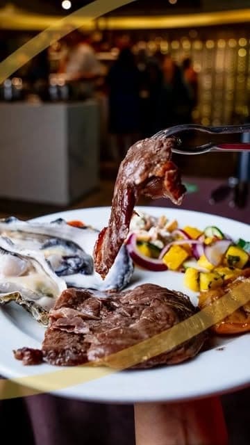 Rodizio steak carved tableside onto a plate of grilled vegetables at Os Segredos Da Carne, Bella Vista, Panama City