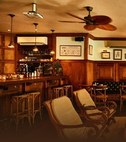 Barra de madera con estante de botellas iluminado y salón en Pedro Mandinga Rum Bar, Casco Viejo, Ciudad de Panamá