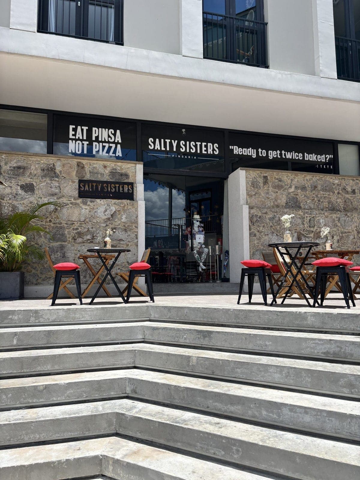 Stone-clad storefront and patio of Salty Sisters Pinsaria, Casco Viejo, Panama City