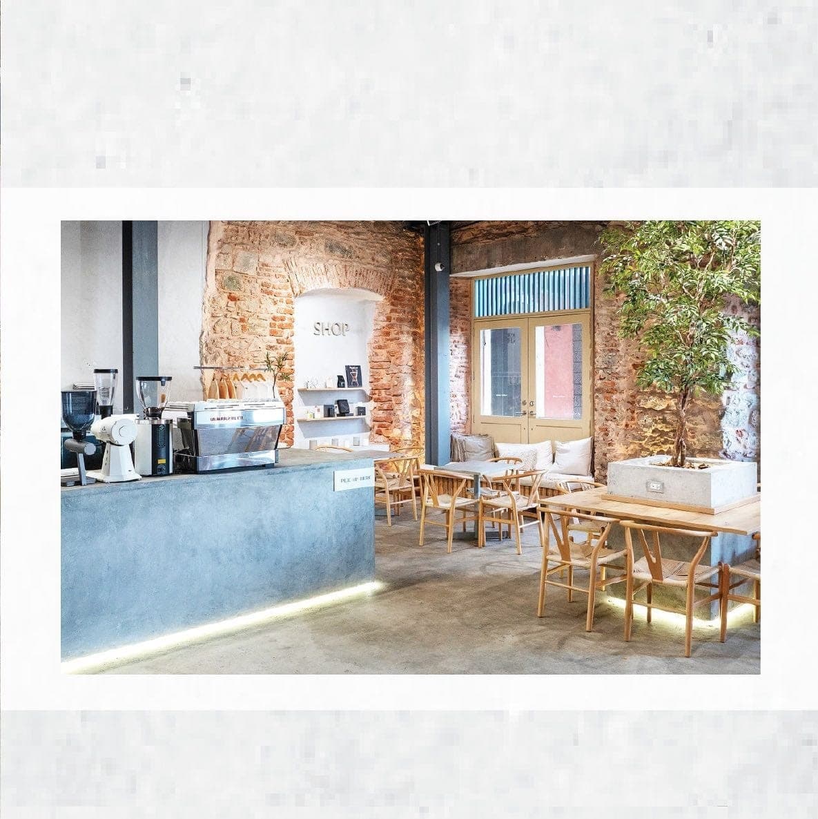 Concrete coffee bar with espresso machine and exposed brick walls at Sisu Coffee Studio, Casco Viejo, Panama City