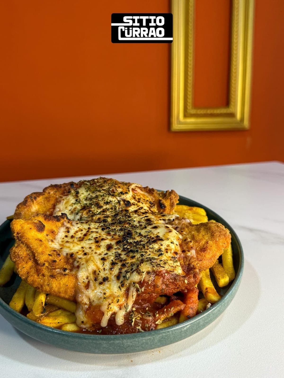 Pollo a la parmigiana sobre papas fritas en Sitio Cürrao, Bella Vista, Ciudad de Panamá