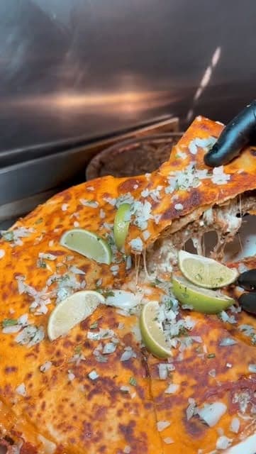Griddled birria quesataco with melted cheese, onion and lime at Tacos El Rey, San Francisco, Panama City